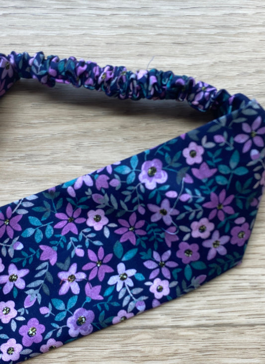 Blått hårbånd med lilla blomster